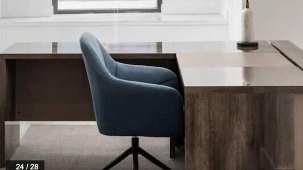 A modern office space with a desk, chair, and pendant lighting.
