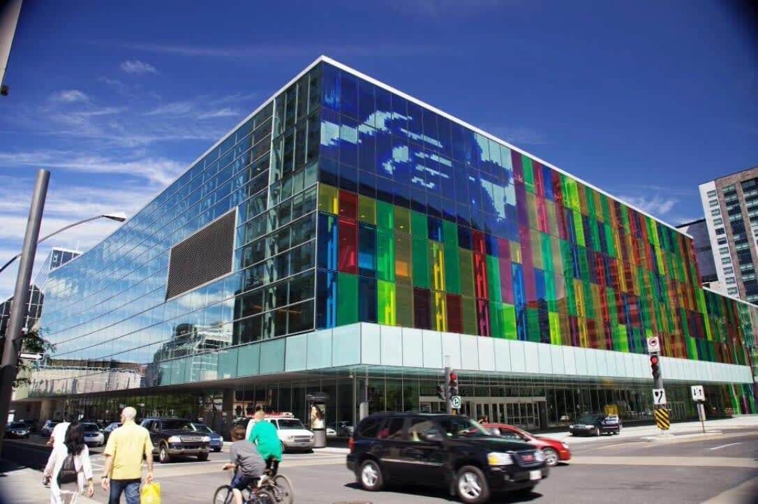 A modern building with a glass facade and a colorful pattern.