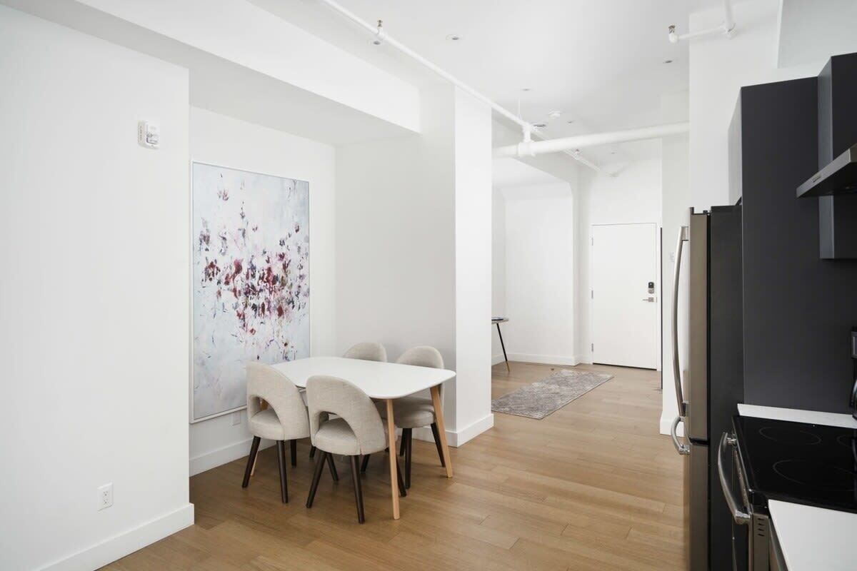 A modern kitchen with a black stove, white cabinets, and a white refrigerator.