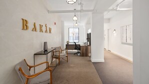 A modern office space with a desk, chairs, and a 'BARI' sign on the wall.