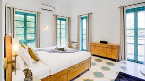 Un dormitorio con cama de madera, cómoda y ventilador de techo.