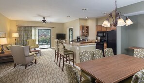 Amplia sala de estar con comedor, cocina y un balcón con vistas.