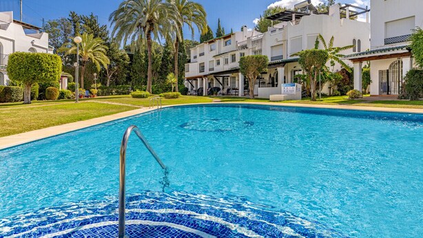 A swimming pool with a clear blue water surface, surrounded by lush greenery and palm trees. - Casa Chic de Ensueño, BBQ Azotea, 9 Piscinas, Golf (Marbella)