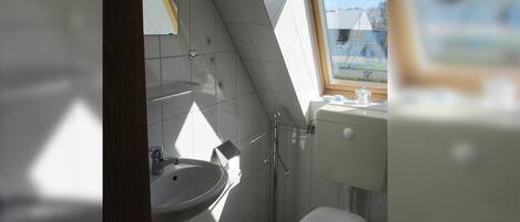 Un bagno piccolo con lavandino, WC e finestra.