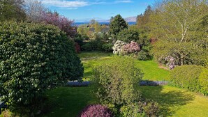 Un jardín bien cuidado con diversas plantas en flor y una vista despejada del paisaje circundante.