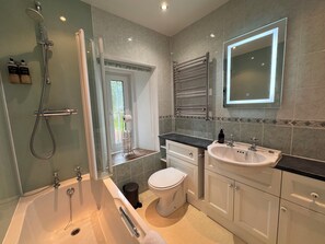 A modern bathroom with a bathtub, toilet, sink, and a glass-enclosed shower. - Glenrigh House - Truly special home with beautiful gardens and church ruins.  (Onich)