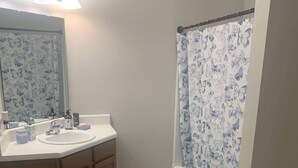 A bathroom with a sink, mirror, and shower curtain. - Newly remodeled 2-bedroom condo in Oxford!  (Oxford)