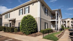 A two-story apartment building with a flat roof, a covered front porch, and a small front yard with a hedge. - Newly remodeled 2-bedroom condo in Oxford!  (Oxford)