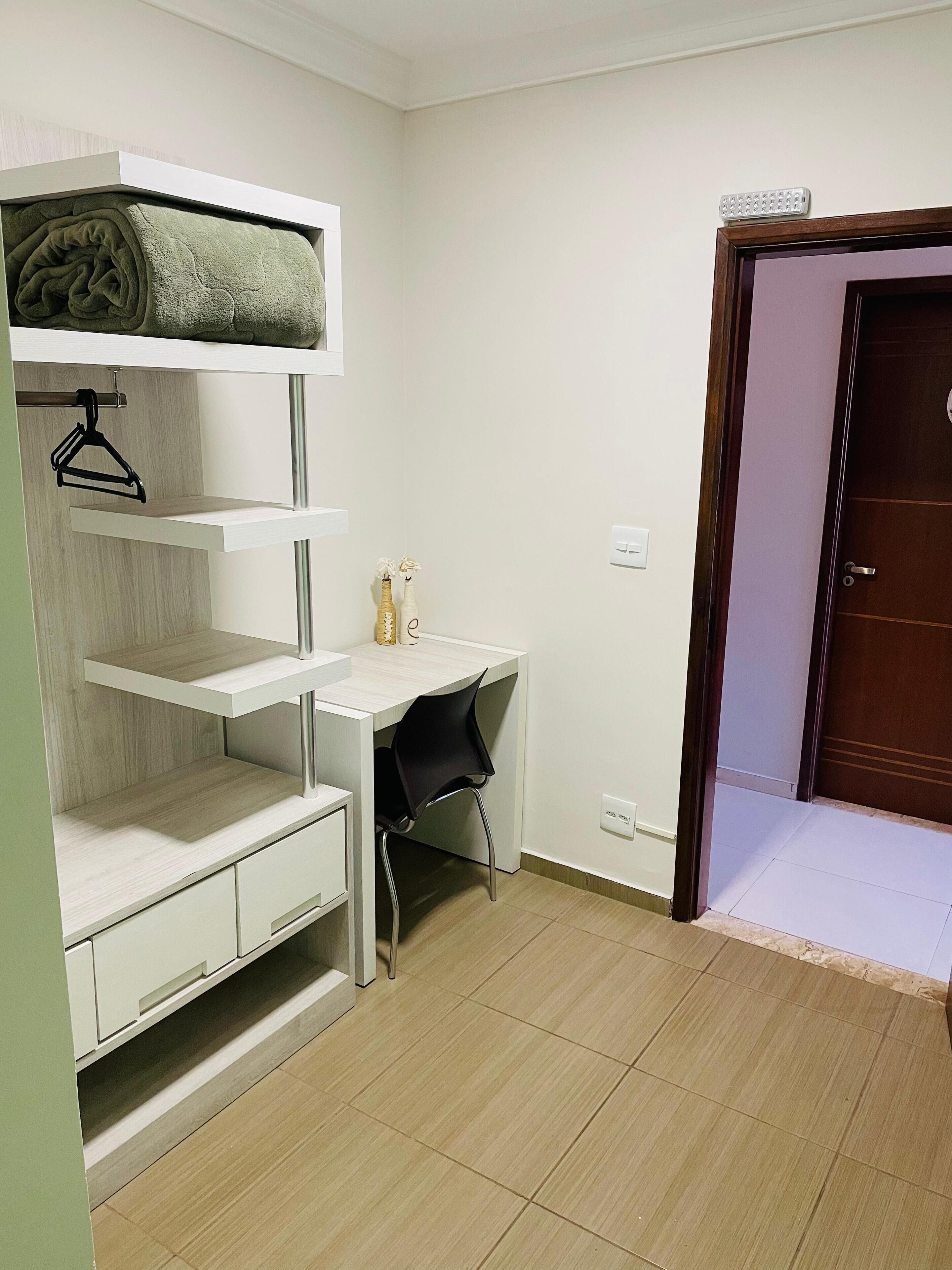 A compact room with a bunk bed, a desk, and a chair.