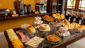 Une table de buffet proposant divers plats et un coin café.