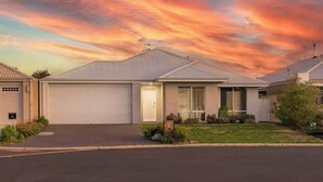 Une maison d’habitation avec un garage, une pelouse devant et une allée.