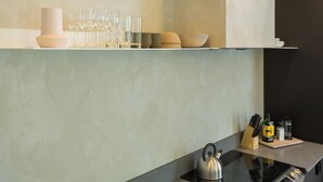 A modern kitchen with a black countertop, a kettle, and various kitchen utensils. - HOMA-Comfort&Style-1BR-Spacious-Natural Light-FeelHome-A/C-SelfCheckIn-Metro (Montréal)