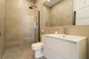 A modern bathroom with a glass-enclosed shower, a white toilet, and a vanity with a mirror. - HOMA-Comfort&Style-1BR-Spacious-Natural Light-FeelHome-A/C-SelfCheckIn-Metro (Montréal)