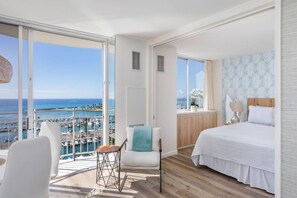 A modern bedroom with a large window overlooking a marina. - Ilikai Collection # 12. Corner Oceanfront condo ! (Honolulu)