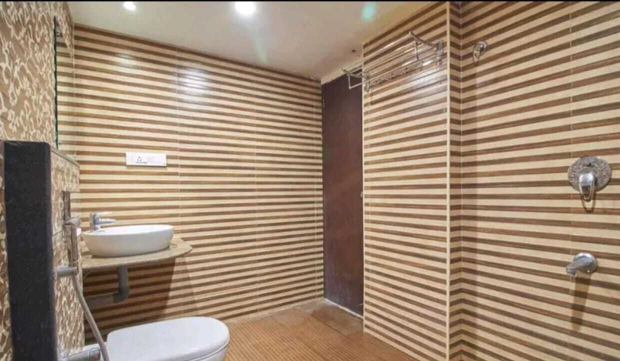 A bathroom with striped walls, a sink, and a shower.