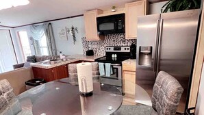 A compact kitchen with a central island, a microwave, a stove, and a refrigerator. - 2 bedrooms, 3 beds, 2 bathrooms cozy house by the bay. (Bacliff)
