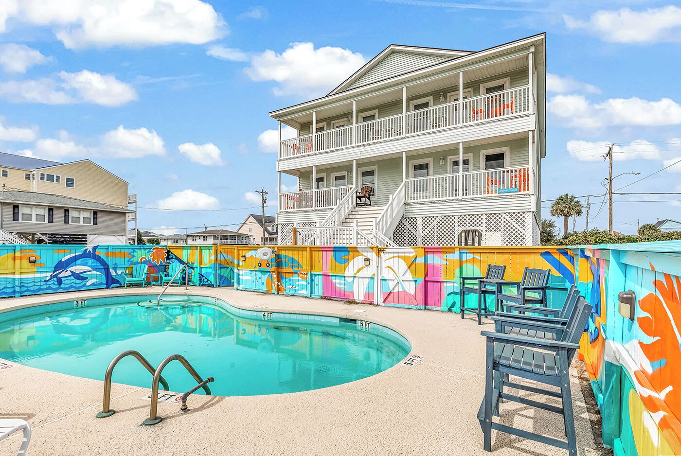 Our in-ground swimming pool, surrounded by an artist painted mural, and seating