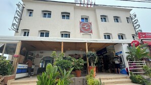 A building with a sign for a rooftop bakery and a visible Coca-Cola sign. - Locals Taghazout Surfcamp (Taghazout)