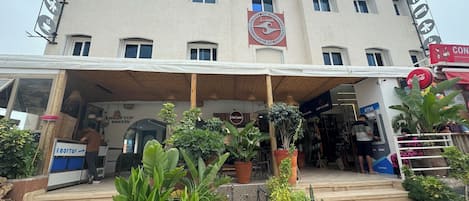 A building with a sign for a rooftop bakery and a visible Coca-Cola sign.