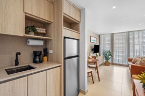 A modern kitchen with a built-in refrigerator, a coffee maker, and a sign that reads 'COFFEE'.