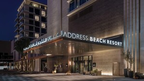 Ein moderner Hotelzugang mit einem Schild, das "Address Beach Resort" zeigt.