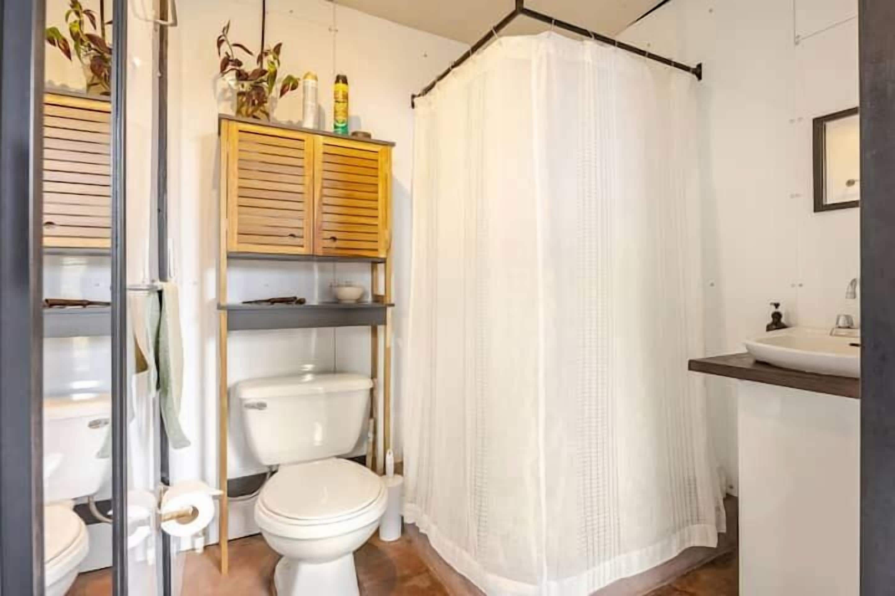 Ein Badezimmer mit Toilette, Duschvorhang und Waschbecken.
