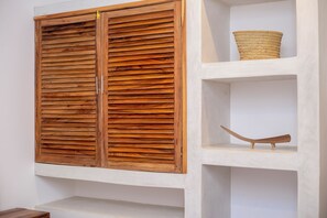 Simple, functional space with a wardrobe and shelving unit.
