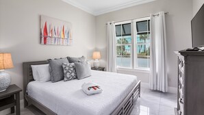 A bedroom with a bed, nightstands, a painting, a window with curtains, and a ceiling fan. - 948B - 4BR $700+ in freebies incl golf, Pool (Miramar Beach)