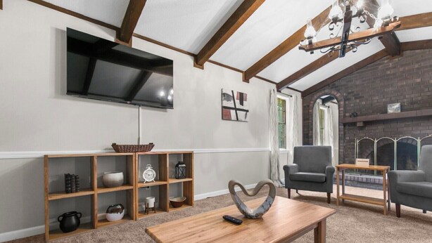 A living room with a TV, wooden shelves, a fireplace, and two armchairs. - Family Friendly in Forestdale  (Birmingham)