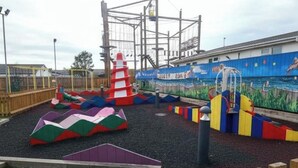 A playground with colorful play structures and a mural on the wall. - 3 Bedroom Caravan to Hire (Abergele)