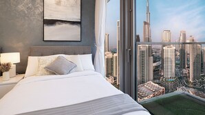 Une chambre d’hôtel moderne avec un grand lit, une vue sur la ville et un tableau abstrait encadré accroché au mur.