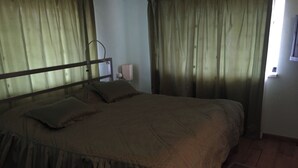 A bedroom with a bed, curtains, a nightstand, and a wall-mounted light. - Gosh Dream House (Gosh)