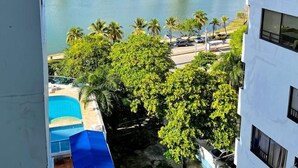 A view of a city skyline with high-rise buildings, a body of water, and palm trees. - Estudios Mirador del Laguito (Cartagena)