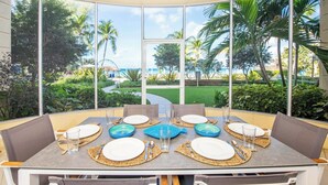 A dining table set for six with a view of a tropical landscape.