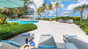 A poolside area with lounge chairs, umbrellas, and a pool.