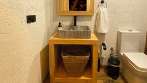 A small bathroom with a wooden vanity, a mirror, a sink, a toilet, and a wooden floor. - Chalet Sapanca (Sapanca)
