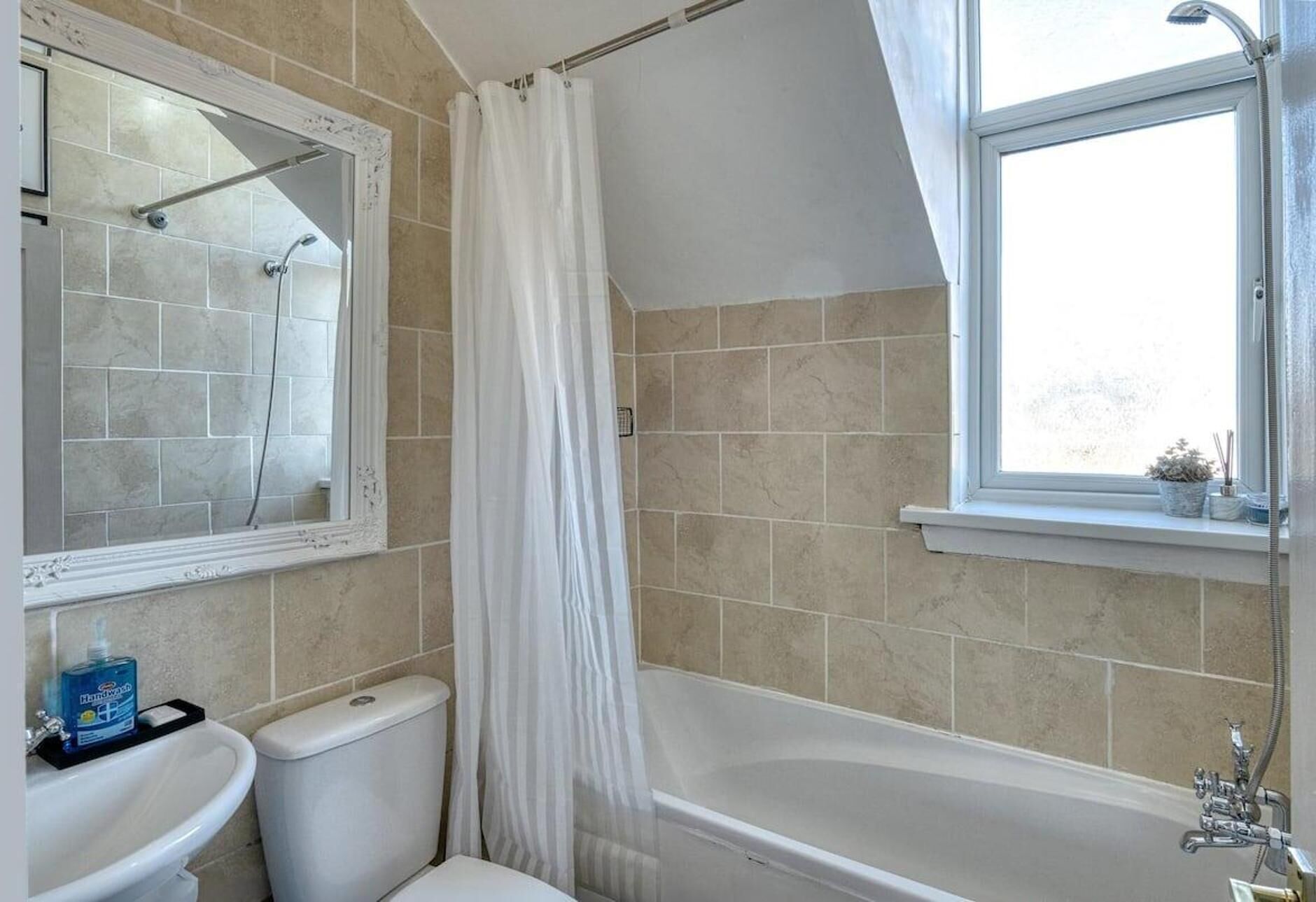 A bathroom with a bathtub, toilet, and sink.