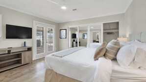 A modern bedroom with a large bed, a TV, and a walk-in closet. - Spacious 4BR+Den w/ Pool, Jacuzzi, BBQ, Near Strip (Las Vegas)