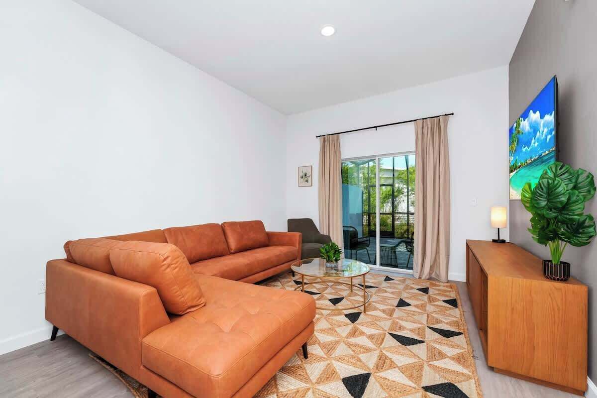 A modern living room with a sofa, coffee table, and a large TV.