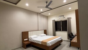 Una camera da letto moderna con un letto, comodini, una scrivania e una ventola a soffitto.