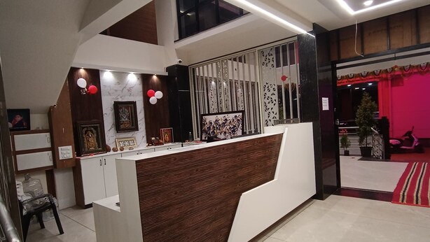 Un'area reception dal design moderno, con una scrivania, un orologio e un pannello decorativo a motivi geometrici.