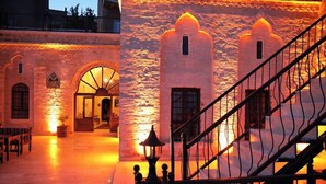 A courtyard with a stone wall, a staircase, and a lamp post. - Kasim Efendi Konagi (Mardin)