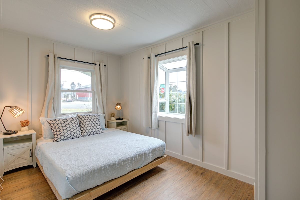 A bedroom with a bed, nightstands, a window, and a ceiling light.
