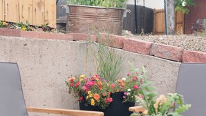 Eine Terrasse im Freien mit Holzmöbeln und Topfpflanzen.