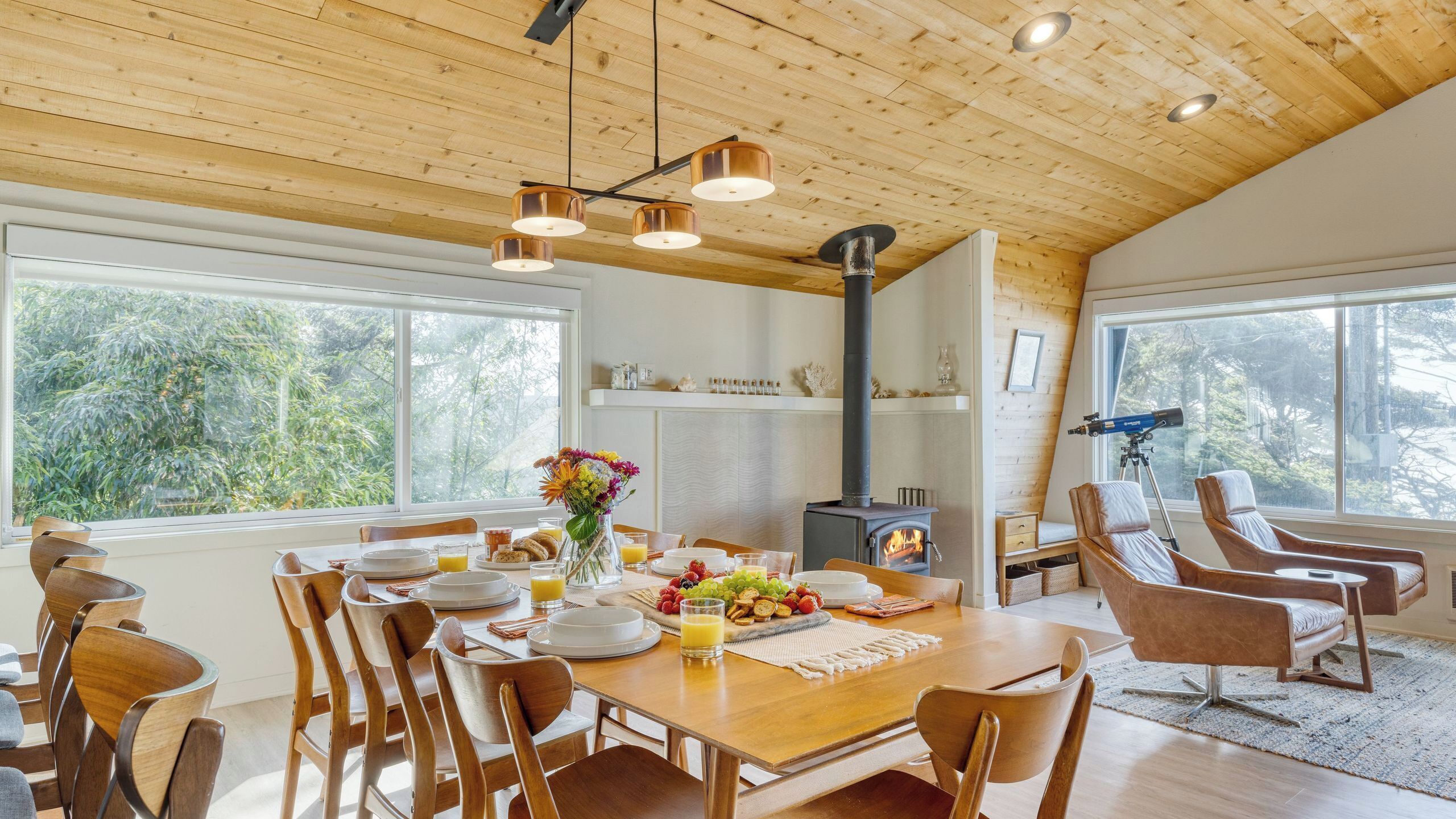 Ein Essbereich mit Holztisch, Stühlen und Kamin.