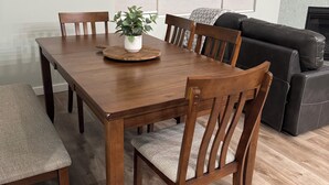 A dining area with a wooden table, four chairs, and a potted plant. - City Retreat, 2 bdrm near Airport (Anchorage)