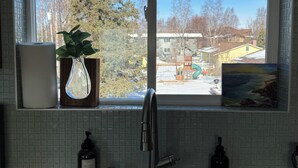A kitchen with a window, a sink, and a potted plant. - City Retreat, 2 bdrm near Airport (Anchorage)