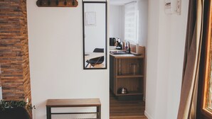A dining area with a wooden table and a black hat on it. There is a mirror on the wall and a kitchen in the background. - Quiet two-bedroom house on the banks of the Seine with parking space. Outdoor terrace (Cleon)