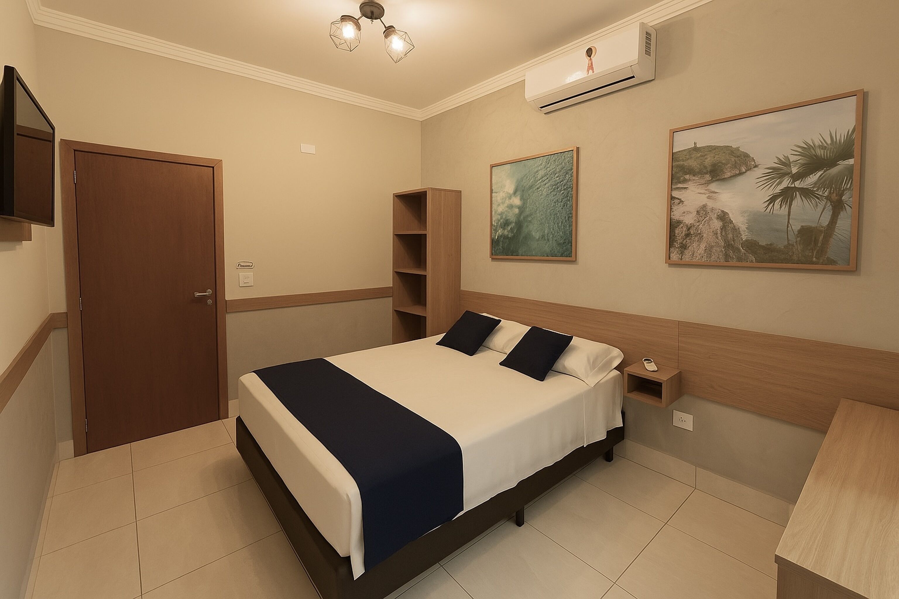 A bedroom with a bed, bedside table, nightstand, wall-mounted TV, and artwork.