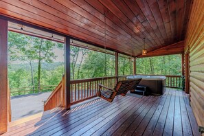 A wooden deck with a hot tub, a swing, and a view of the forest. - Cottage w/ Hot Tub: 3 Mi to Downtown Blue Ridge! (Blue Ridge)